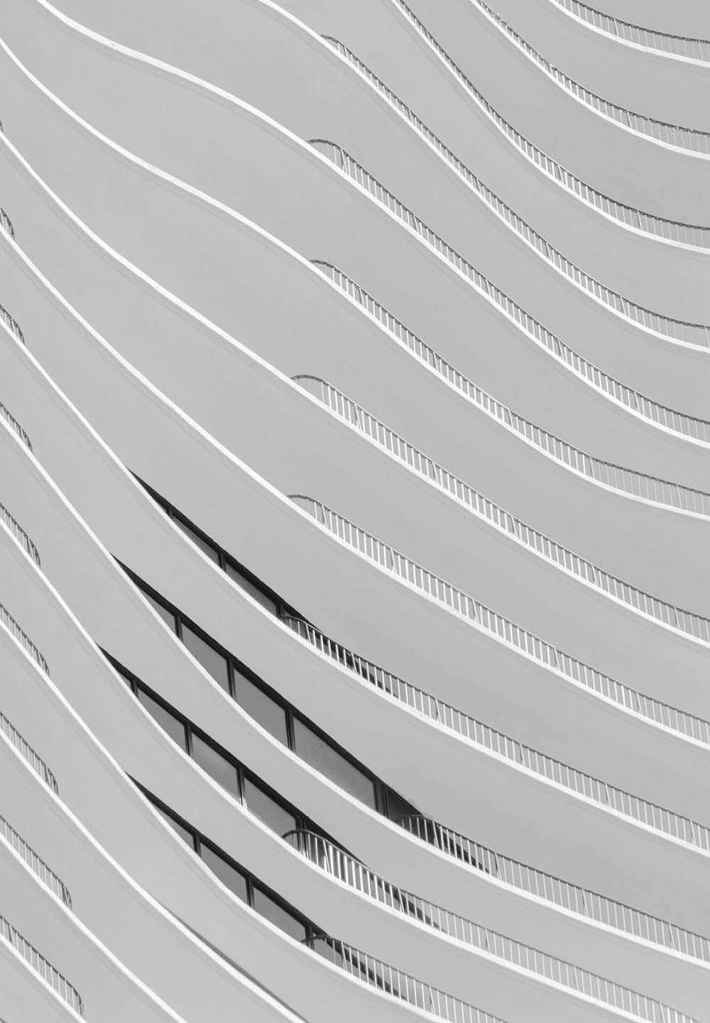 Schwarzweißfotografie von Fensterreihen mit Balkonen eines modernen Gebäudes